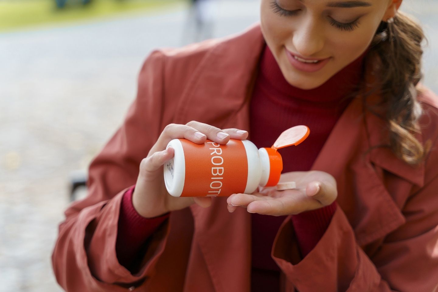 Slika mlade žene koja uzima probiotik i brineo svom zdravlju.